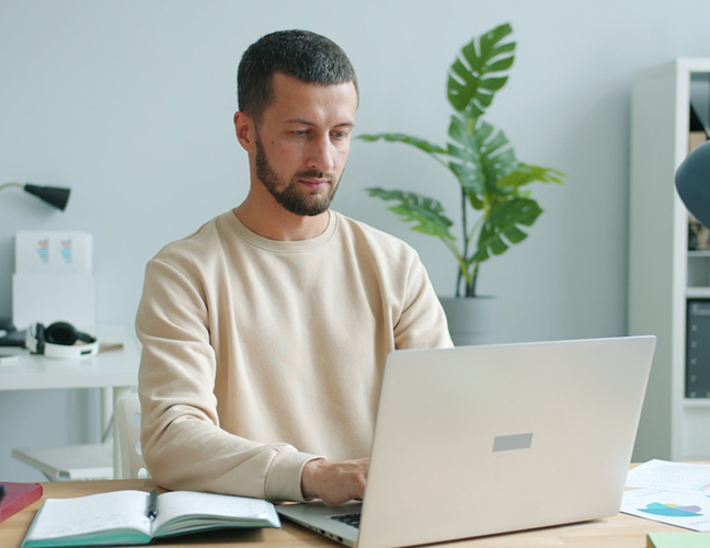 Man with beard working on laptop